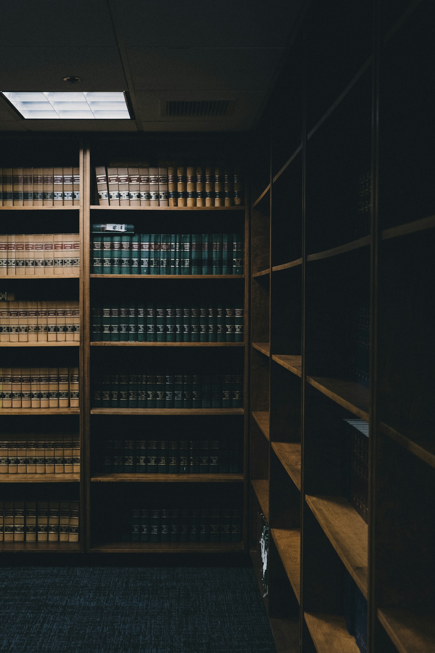 Estante de livros jurídicos em escritório de advocacia, com iluminação quente